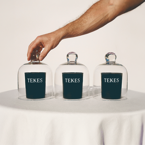 Three TEKES candles with cloches on a table in the sun